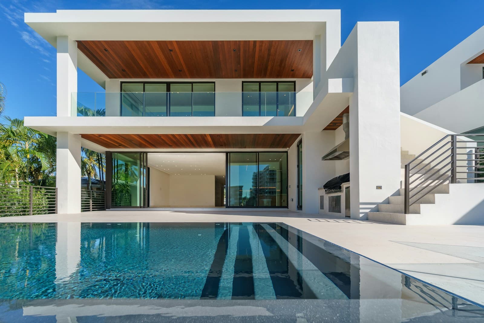 Modern white villa with a sunlit swimming pool
