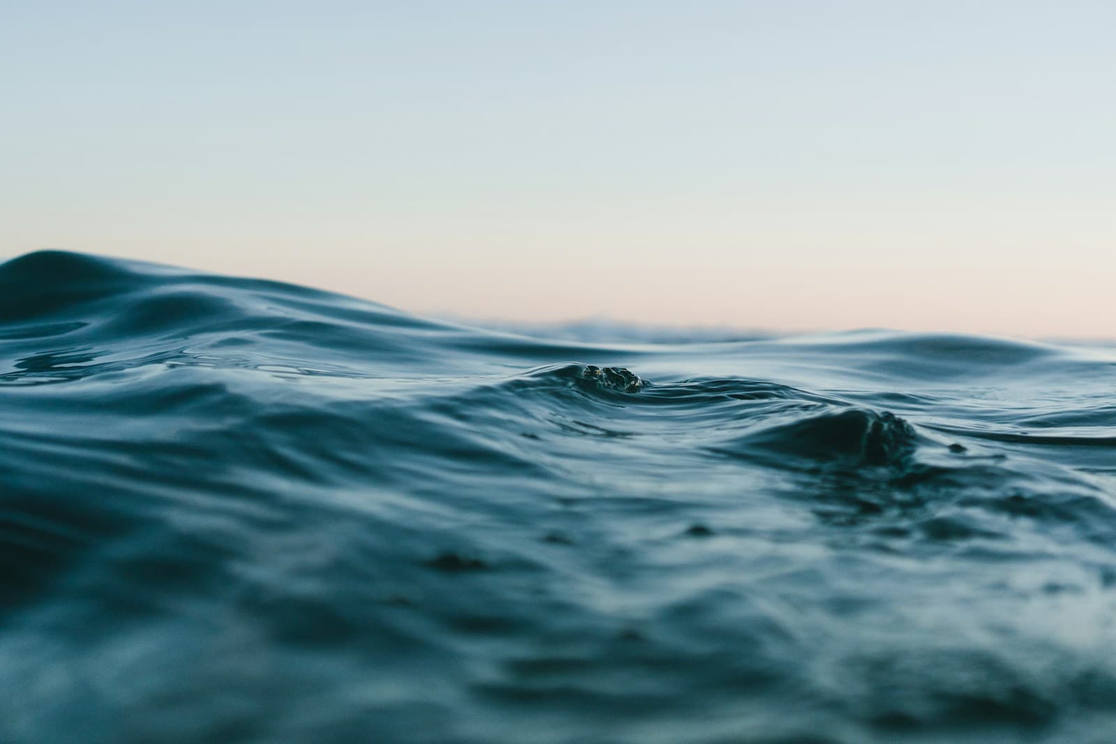 Gentle ocean waves beneath a pale sky